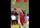 Between a pair of Alma/Pepin defenders, Jackson Gosse takes it to the hoop in the second half of the Falcons’ game against the Eagles  last Tuesday night. Looking on for the Falcons is Head Coach Mike Malmquist. 