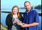Sarah and Scott hold the bottle alongside the Mississippi River near the location he threw it in 35 years agop. 