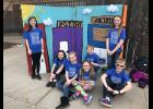 The “Tune Transformers” posed next to props from their team challenge, which involves bringing scenes from a story they created to life via music and lyrics.