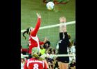 Maddie Schmoker tips the ball over the outstretched hands of a Lewiston-Altura defender in Game 3 action last Monday night. Looking on is Maggie Klees (8). 