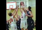 Center Mike Guidinger grabs a rebound away from Hope Lutheran’s 6’6 senior Andrew Fratzke during the first half of the Falcons’ 68-35 win over the Patriots in rural Lewiston Saturday. Jackson Gosse, left, gets in on the action for the Falcons, as well. 
