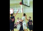 Zach Kjeseth backhands a layup in for two points during the early stages of Saturday’s 68-35 win over Hope Lutheran at Immanuel Lutheran School in rural Lewiston. Defending are the Patriots’ Josiah Sandcork (32), Andrew Fratzke (11) and Hunter Russeau (31). Also pictured is W-K’s Marcus Meyer.