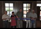 Craig Pedersen (center), Hope Gospel Mission Operations Director, cut the ribbon during a brief ceremony held during the grand opening. Other Hope Gospel reps and Mondovi Mayor Treig Pronschinske (right) assisted Pedersen. Pronschinske was one of several contractors who donated time and materials to the building renovation project, completing the finish work on the front entrance (back).
