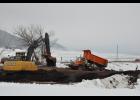 Heavy equipment operated at the site of the damaged bridge northeast of Waumandee on Tuesday morning. Trucks are in the process of hauling in loads of rock to build a bypass bridge, allowing traffic to pass through the area once it is completed.