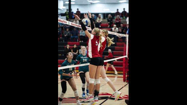 No. 5 Hailey Arens and no. 7 Piper Wobbe go side-by-side at the net for a block against the Fillmore Central Falcons.