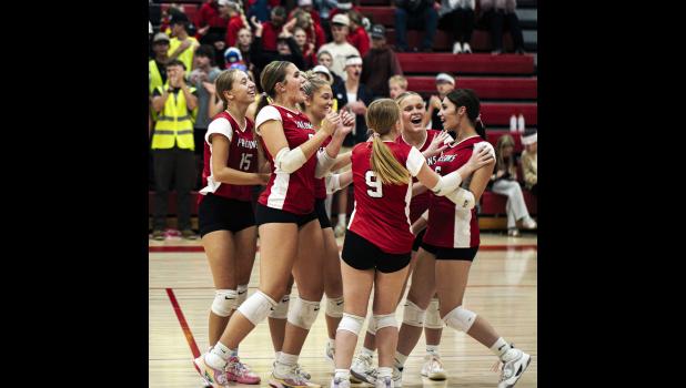 The Falcons cheer around their teammate Hannah Arens-Silker as she lands an ace.