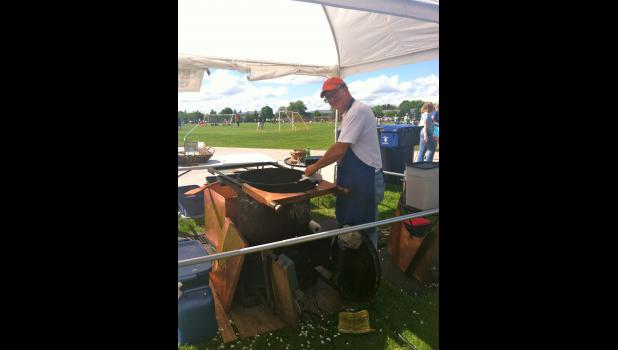 Joel House wipes down his cast iron kettle at a festival.