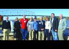 The entire group poses for a picture by the Bouquet Fountain next to the Eagle Center and in front of the Clickner Interstate Bridge over the Mississippi River Thursday. From left: Preston Cook, Victoria Moore, Barry Hill, Don Jacoby, Eileen Hanson, Mayor Rollin Hall, Lt. Governor Tina Smith, State Senator Matt Schmit and Rolf Thompson.